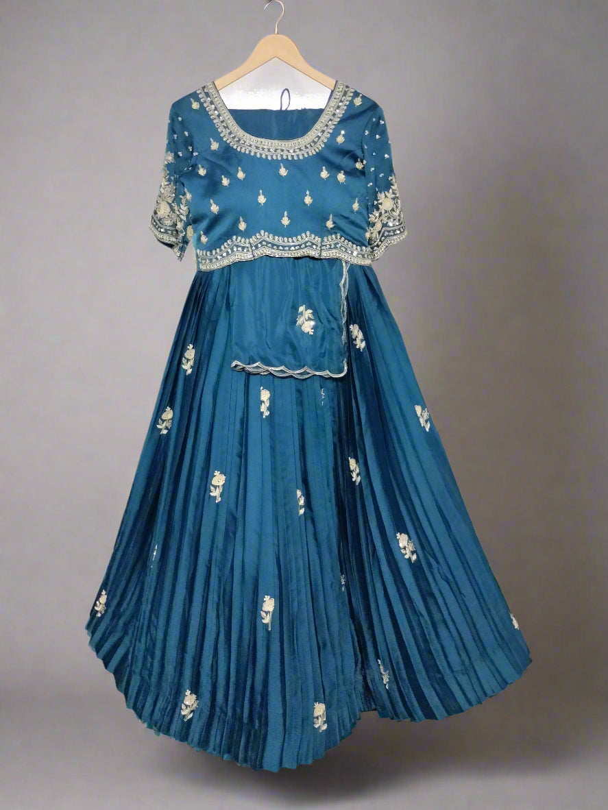 Blue embroidered traditional outfit on a hanger against a neutral background
