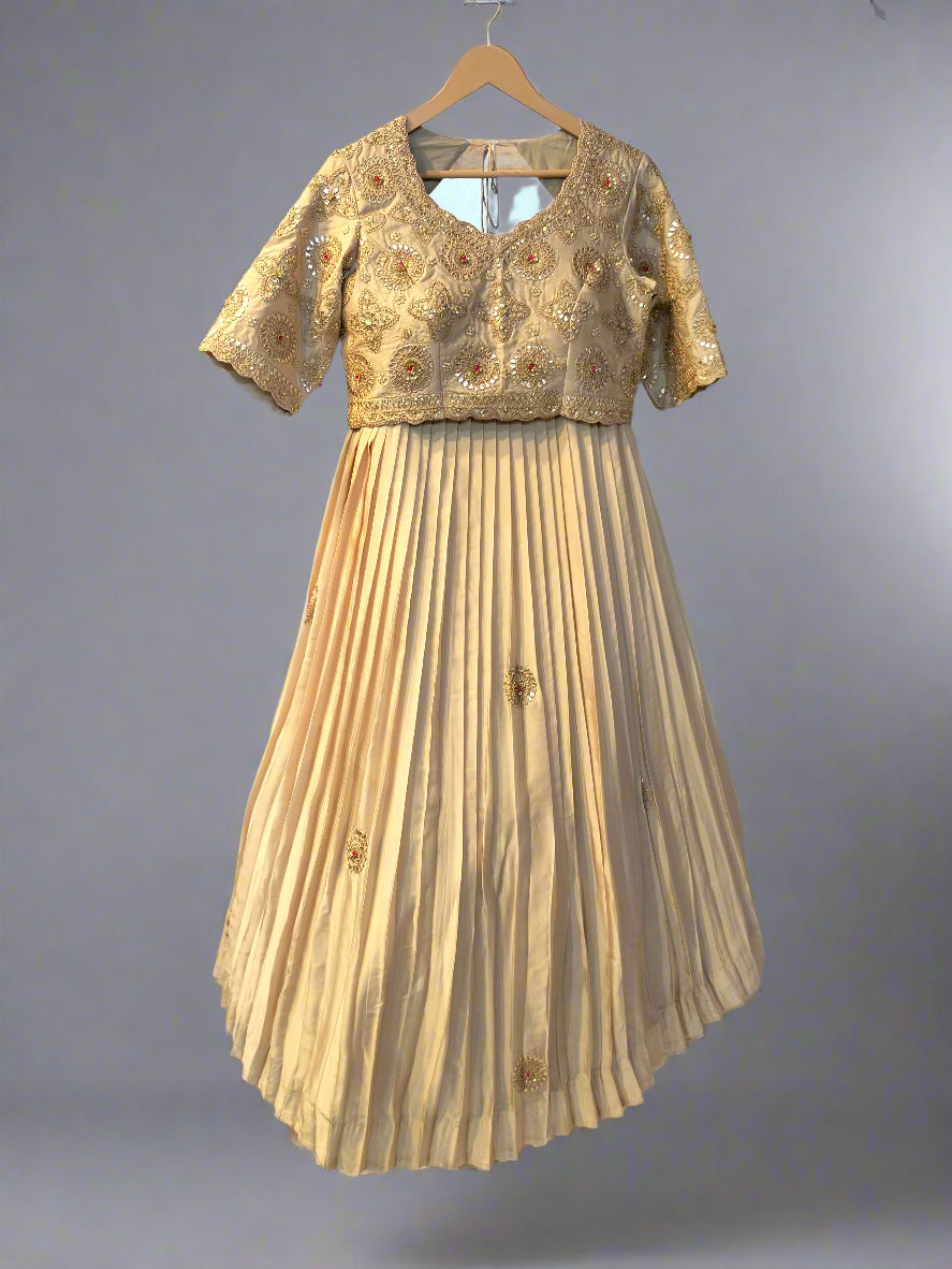Beige dress with floral embroidery on a hanger against a blue wall.