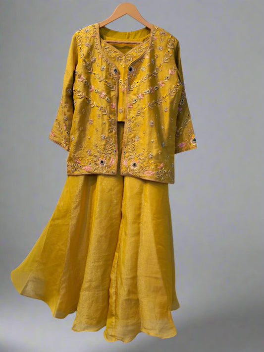 Yellow embroidered outfit on a hanger against a plain background