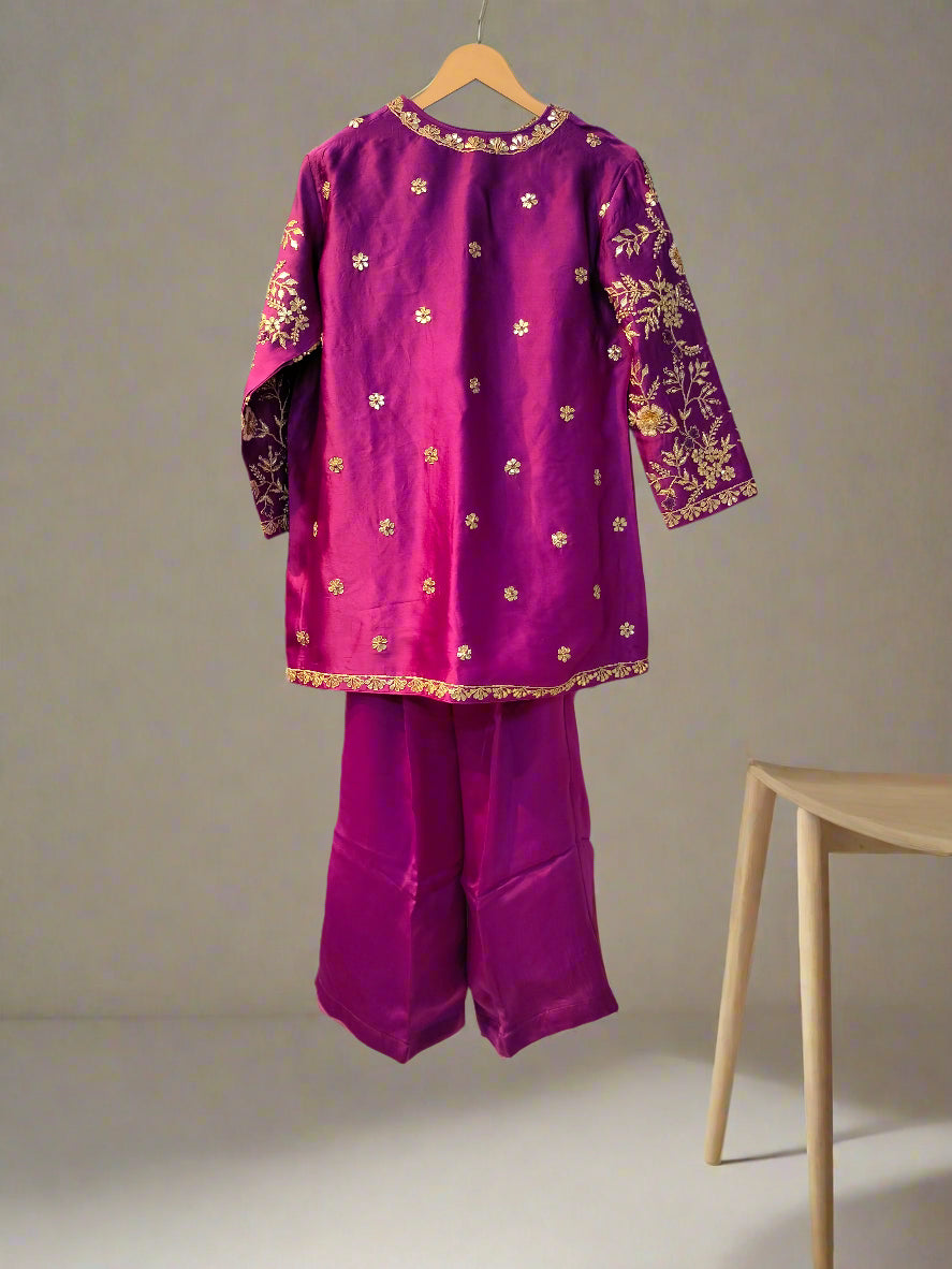 Purple traditional outfit with floral patterns on a hanger against a reflective surface.