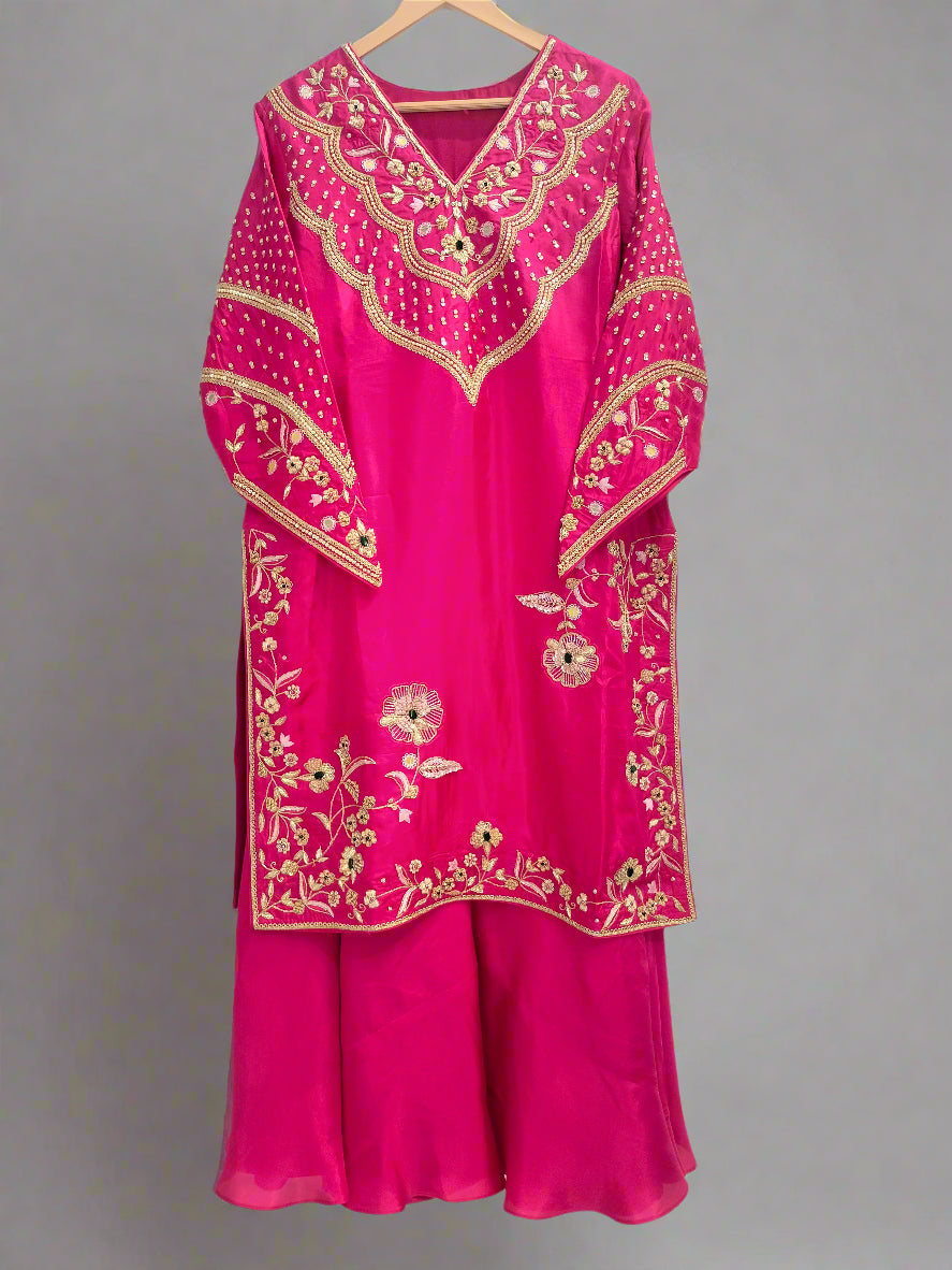 Pink traditional outfit with gold embroidery on a white background