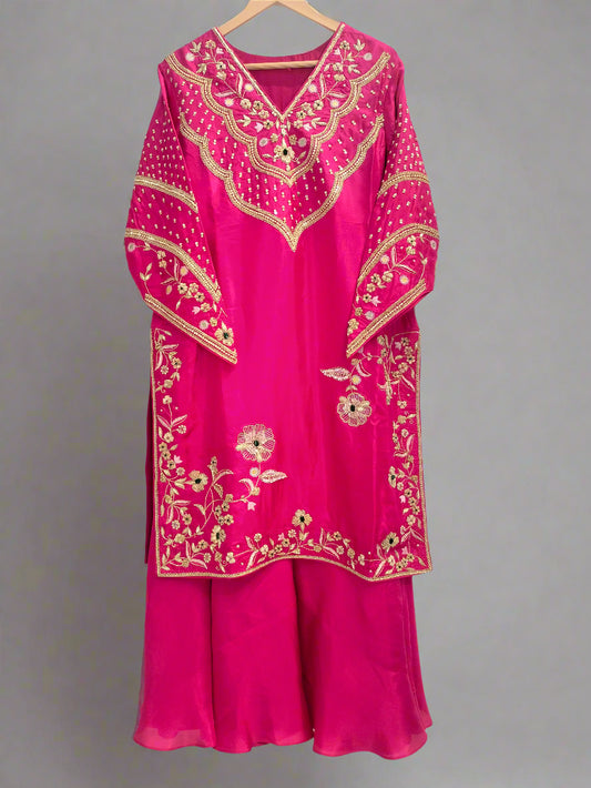 Pink traditional outfit with gold embroidery on a white background