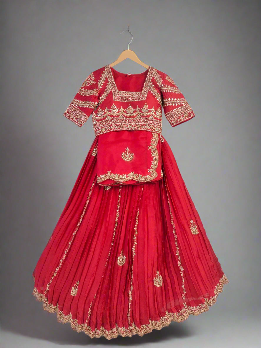 Red traditional outfit with gold embroidery on a hanger against a neutral background