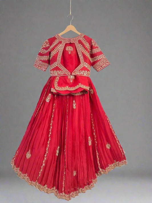 Red traditional outfit with gold embroidery on a hanger against a white background